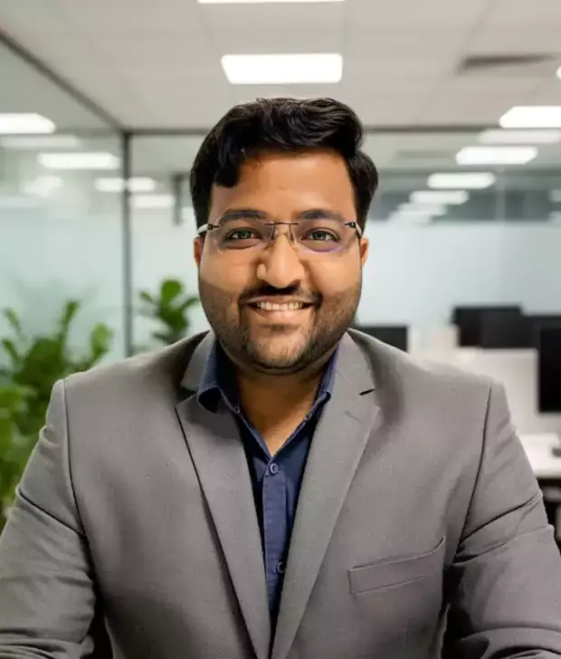 Shrinidhi Kulkarni, Founder of AiVORA Techlabs, smiling in a grey blazer in an office